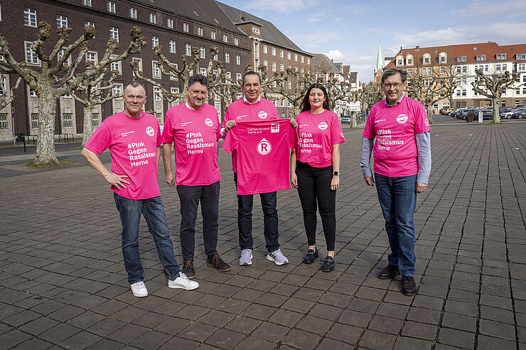 5 Personen stehen auf einem Platz.