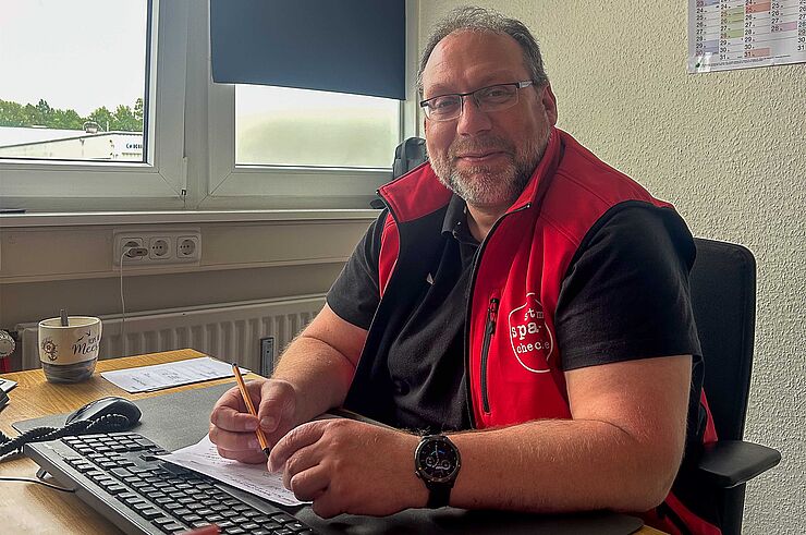 Ein Mann sitzt am Schreibtisch.