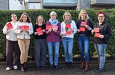 Sieben Frauen stehen nebeneinander.