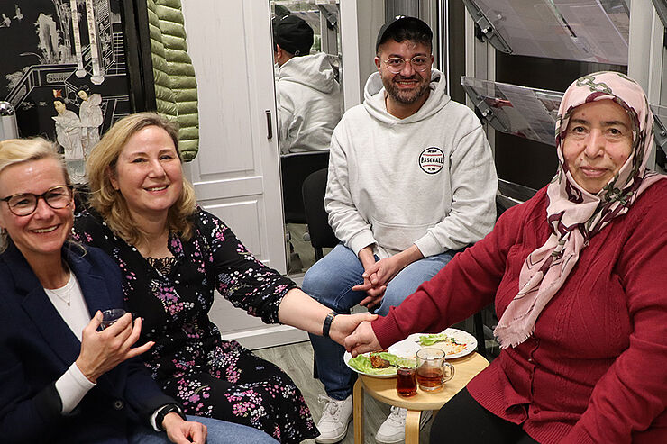 Drei Frauen und ein Mann sitzen zusammen.